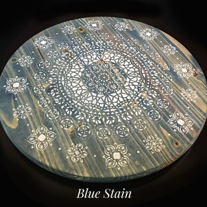 May include: A round wooden tray with a blue stain finish. The tray features a white mandala design with intricate details. The text "Blue Stain" is printed below the tray.