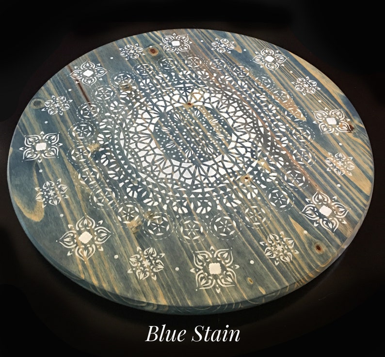 May include: A round wooden tray with a blue stain finish. The tray features a white mandala design with intricate details. The text "Blue Stain" is printed below the tray.