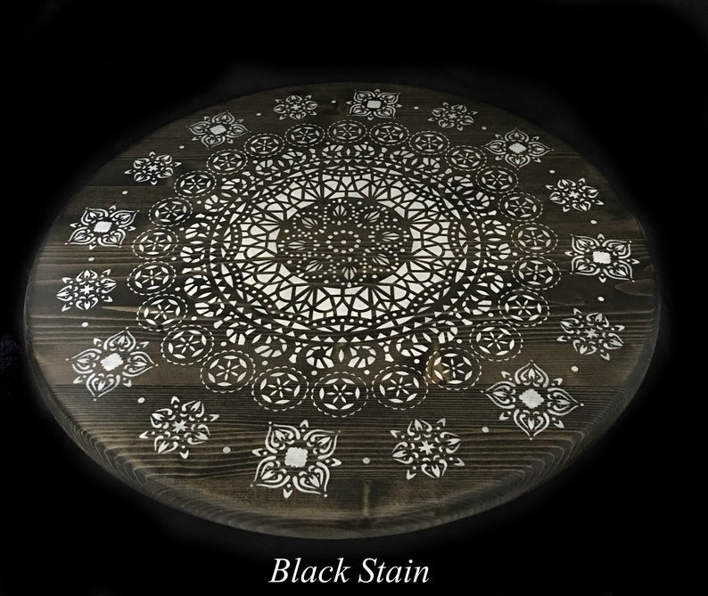 May include: A round wooden table top with a white mandala design painted on it. The table top is stained black. "Black Stain" is written in white text below the table top.