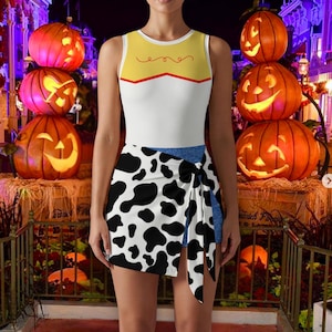 May include: A sleeveless bodysuit featuring a yellow upper chest panel with a red decorative line, a white midsection, and a wrap-style skirt overlay with a black and white cow print pattern. The garment includes a blue denim-textured base layer.