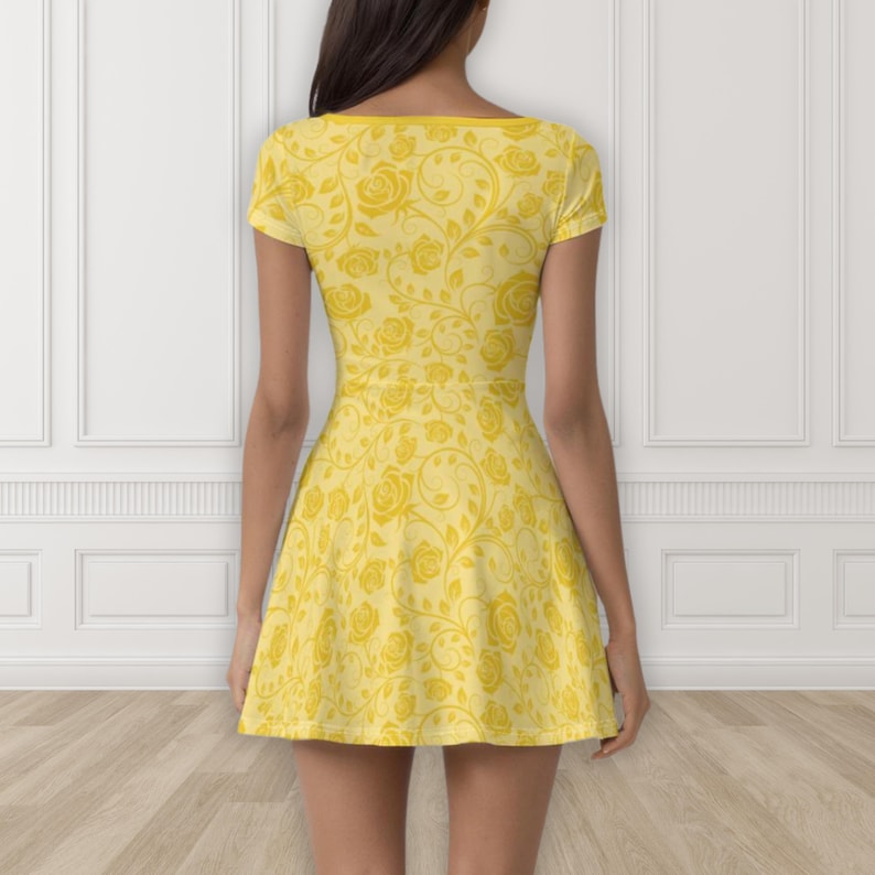 May include: A yellow skater dress with a floral rose pattern. The dress features short sleeves and a scoop neckline. The roses and vines are in a lighter shade of yellow, creating a contrasting design.