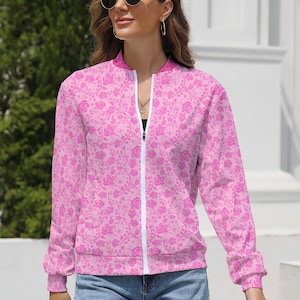 May include: Pink bomber jacket with a rose pattern. The jacket has a white zipper and cuffs. The floral design is a lighter shade of pink against a darker pink background. The jacket has a stand-up collar.