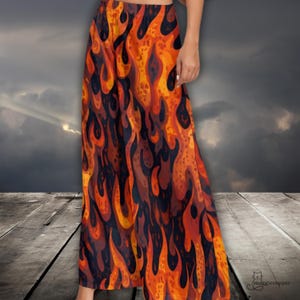 May include: Wide-leg pants with a vibrant flame pattern in shades of orange, red, and brown. The design resembles stylized flames against a dark background. The pants are made of a flowing fabric.