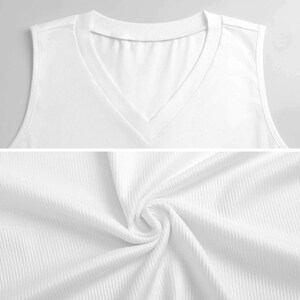 Puede incluir: Primer plano de una camiseta sin mangas blanca de punto acanalado con cuello en V. La tela es suave y parece ser un material ligero. La camiseta sin mangas tiene un dise&ntilde;o simple y cl&aacute;sico, adecuado para usar solo o en capas.