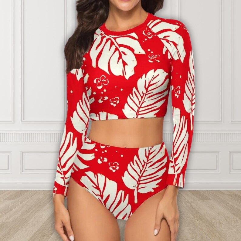 Puede incluir: Traje de ba&ntilde;o de dos piezas rojo y blanco. El top corto de manga larga y la braguita de cintura alta presentan un estampado de grandes hojas blancas y peque&ntilde;os detalles florales. El traje de ba&ntilde;o est&aacute; hecho de un material liso y el&aacute;stico.
