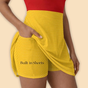 May include: A sleeveless dress with built-in shorts. The top is red, and the skirt is yellow with a honeycomb pattern. The text "Built-in Shorts" is visible on the shorts.