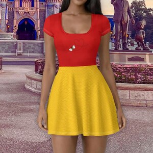 May include: A red and yellow dress with a scoop neck and short sleeves. The top is red with a small graphic of a bee and a heart. The skirt is yellow with a small dot pattern. The dress is knee-length.
