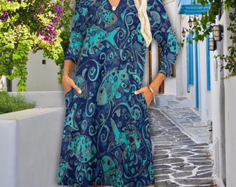 May include: A knee-length dress with a V-neck and three-quarter sleeves. The dress features a dark blue background with a repeating pattern of teal and blue fish and swirling designs. It has two pockets and the brand name "maggiecopper" is visible.