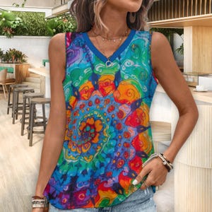 Puede incluir: Una camiseta sin mangas con cuello en V con un vibrante y colorido estampado tie-dye. El dise&ntilde;o presenta remolinos de azul, verde, naranja y rojo. La camiseta tiene un ribete azul alrededor del cuello y las sisas. Un colgante plateado cuelga del escote.