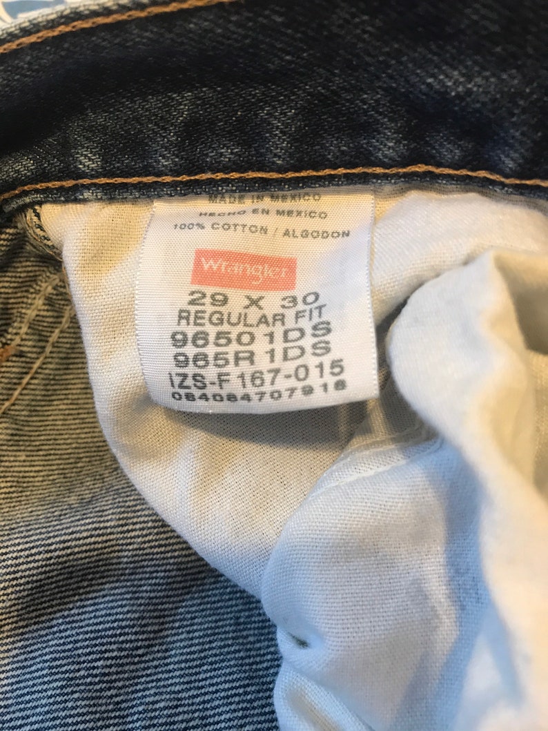 May include: A white tag with black text that reads "MADE IN MEXICO HECHO EN MEXICO 100% COTTON/ALGODON Wrangler 29 X 30 REGULAR FIT 96501DS 965R 1DS IZS-F 167-015 084084707918".