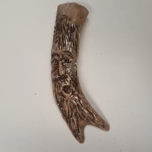 Könnte beinhalten: Eine geschnitzte Holzfigur eines Gesichts mit langem Bart. Die Figur ist aus hellem braunem Holz gefertigt und hat eine dunkelbraune Beize.