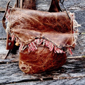 May include: A white ceramic mug with a black handle and the text "But First, Coffee" in a handwritten style. The mug is on a white surface. The mug is approximately 4 inches tall.