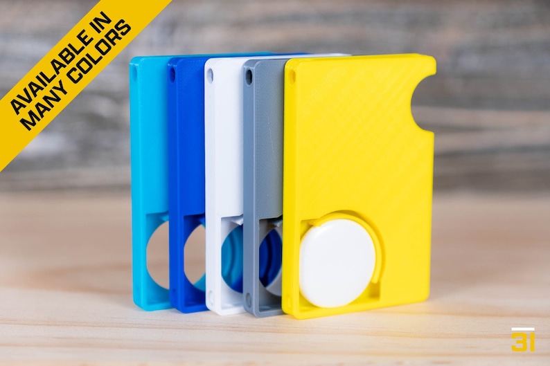 May include: Five different colored keychains with a round button on the side. The keychains are blue, teal, white, gray, and yellow.  Available in many colors.