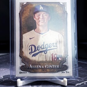 Op de afbeelding: Een honkbalkaart met een honkbalspeler die een blauw-wit honkbaluniform draagt met een blauwe pet met een wit 'LA'-logo. De kaart is een Topps Allen & Ginter 2024 kaart en toont de naam van de speler 'Yamamoto' en het team 'Dodgers'.