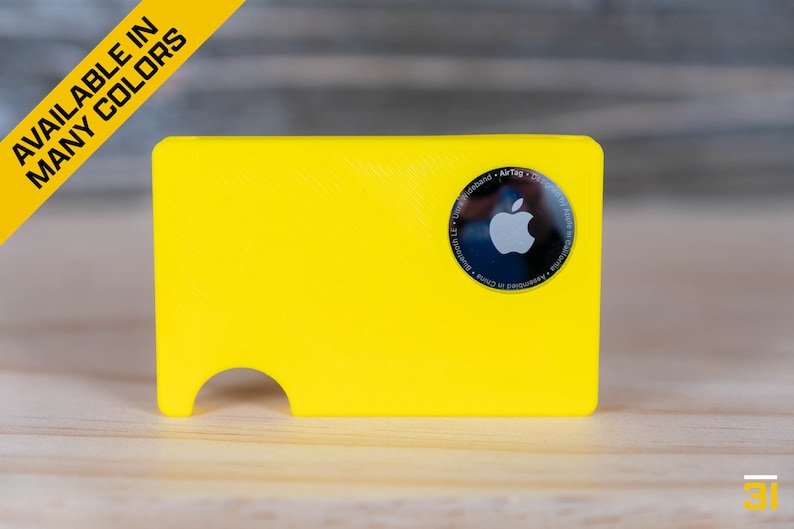May include: A bright yellow plastic card holder with a cut-out for an Apple AirTag. The AirTag is visible in the holder, showing the Apple logo.