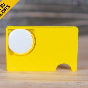 May include: A bright yellow plastic card with a white circle in the center and a small cutout on the bottom. The card has the text "AVAILABLE IN MANY COLORS" on a yellow background.