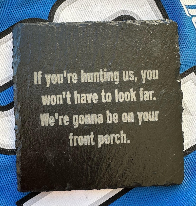 May include: Square black slate coaster with a rough edge. The coaster has white text that reads: "If you're hunting us, you won't have to look far. We're gonna be on your front porch."