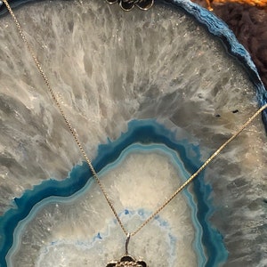 May include: A turquoise and silver pendant necklace and ring set. The pendant and ring feature a turquoise stone with brown veins and a silver setting with a scalloped edge.
