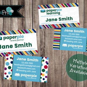 May include: Business cards with the "paperpie" logo and the name "Jane Smith" are displayed against a wood grain background. The cards feature colorful striped and polka dot designs, with contact information and the phrase "Multiple Variations Available."