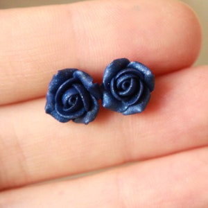 May include: A pair of blue rose stud earrings. The roses are made of polymer clay and have a matte finish.