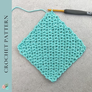 Könnte beinhalten: Ein türkisfarbenes Häkelquadrat mit einer Häkelnadel und Garn. Die Häkelnadel ist mit "E-4 3,50 mm" beschriftet.