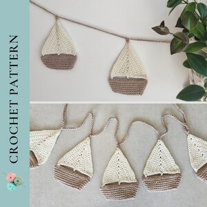May include: A crochet garland featuring a string of sailboats. Each sailboat is made of beige and brown yarn and is approximately 3 inches tall. The garland is perfect for a nautical themed nursery or children's room.