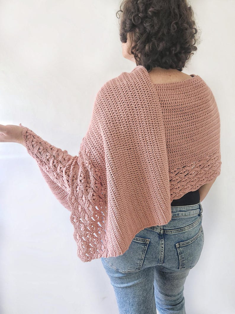 K&ouml;nnte beinhalten: Ein altrosa H&auml;kelschal mit einem einzigartigen Design. Der Schal hat ein strukturiertes Muster an den &Auml;rmeln und Kanten und einen einfachen Stich auf der R&uuml;ckseite. Das Model tr&auml;gt den Schal mit einer blauen Jeans.