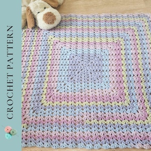 Könnte beinhalten: Eine gehäkelte Decke in Pastellfarben mit quadratischem Design. Die Decke weist eine Mischung aus sanften Farben auf, darunter Rosa, Blau und Gelb. Der Text "CROCHET PATTERN" ist auf der linken Seite des Bildes zu sehen. Ein Stofftier-Hund befindet sich in der oberen linken Ecke.