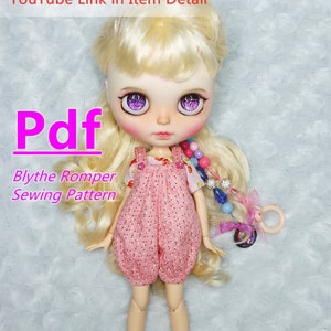 May include: A pink and white polka dot romper sewing pattern for a Blythe doll. The pattern is available as a PDF download. The doll is wearing the romper and has blonde hair and purple eyes.