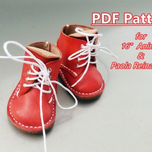 Peut inclure: Une paire de petites bottes en cuir rouge avec des lacets blancs, conçues pour une poupée Animator ou Paola Reina de 40 cm. Les bottes ont des coutures blanches et un intérieur marron clair. Le texte "PDF Pattern" est visible.