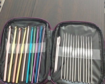 May include: A crochet hook set in a zippered case. The case is open, showing a variety of colourful crochet hooks in shades of pink, orange, yellow, green, blue, and purple. Several silver crochet hooks are also included.