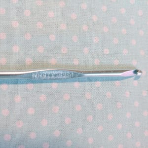 May include: A silver crochet hook with the text "WINSTON 4.75" printed on the handle.