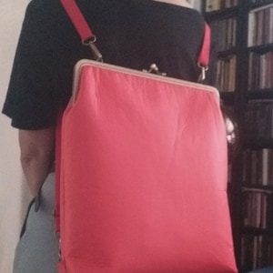 Sac de transport rouge avec ouverture du cadre métallique kiss lock.  Sac à dos convertible de grande taille ou sac à bandoulière ou cartable