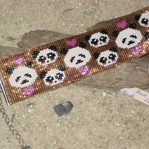 May include: A beaded bracelet with a pattern of panda bears and hearts. The bracelet is made with brown and gold beads and has a silver clasp.
