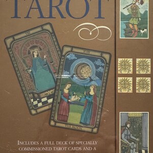 May include: A brown box set of The Golden Tarot, with two tarot cards visible. The cards feature illustrations of figures in medieval clothing. The box has the title in blue. Text reads: Includes a full deck of specially commissioned tarot cards and a 64-page illustrated book.