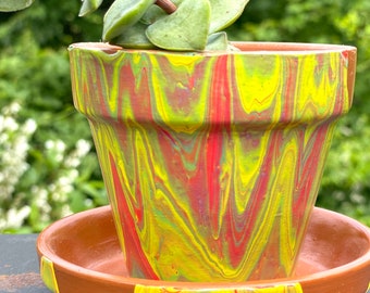 Sunflower-acrylic paint pour on terra cotta pot.