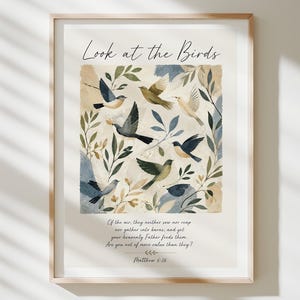Può includere: Una stampa artistica incorniciata con il testo Look at the Birds in alto e un versetto biblico di Matteo 6:26 in basso. L'illustrazione centrale mostra vari uccelli ad acquerello in tonalità di blu, marrone e nero tra foglie e rami.