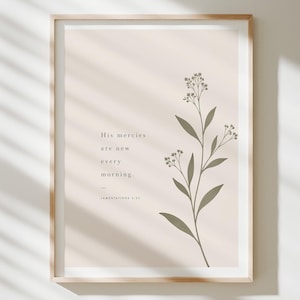 Peut inclure: Une affiche murale encadrée sur fond beige clair avec une illustration botanique vert olive foncé représentant une tige de fleur sauvage. Le texte indique His mercies are new every morning suivi de Lamentations 3:23 en police serif.