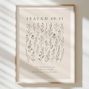 Peut inclure: Une affiche encadrée sur fond beige clair présentant des dessins au trait noir de diverses fleurs sauvages. Le texte indique ISAIAH 40:31 suivi du verset : Those who hope in the Lord will renew their strength. They will soar on wings like eagles.