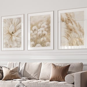 May include: A living room with a beige sofa, decorative cushions, and three framed floral prints. A black marble coffee table and a gold floor lamp are present. The room is decorated with a round ottoman. The colour scheme is neutral.