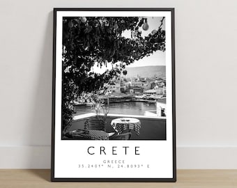 May include: A black and white framed wall art print featuring a harbour view in Crete, Greece. The image shows a terrace with tables under trees, overlooking a waterfront town. Below the photo, the text reads: CRETE, GREECE, 35.2401° N, 24.8093° E.