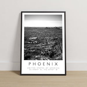 May include: Black and white photograph of Phoenix, Arizona, USA. The image shows a cityscape with buildings and trees. The text "PHOENIX", "UNITED STATES OF AMERICA", and "33.4484° N, 112.0740° W" is printed below the image.
