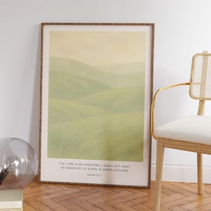 Może przedstawiać: Oprawiony wydruk przedstawiający spokojny krajobraz zielonych wzgórz pod bladym, żółtym niebem. Grafika zawiera tekst "THE LORD IS MY SHEPHERD; I SHALL NOT WANT HE MAKES ME LIE DOWN IN GREEN PASTURES PSALM 23:1". Rama jest w ciepłym brązowym kolorze.
