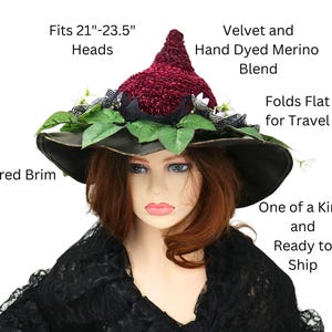 A crochet burgundy and black witch hat with a wired brim. The hat is decorated with green leaves, white flowers, and black lace. The hat is made of velvet and hand-dyed merino blend. The hat is one of a kind and ready to ship. Fits 21 to 23.5 inch heads. Folds flat for travel.