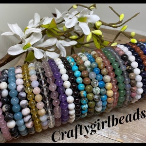May include: A collection of colorful gemstone bracelets stacked together. The bracelets are made with various types of stones, including amethyst, turquoise, and rose quartz. The bracelets are all approximately 6 inches in length and are perfect for layering or wearing individually. Craftygirlbeads is written on the bottom of the image.