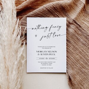May include: A white wedding invitation with black text. The invitation reads "nothing fancy just love" and includes the names Morgan Nelson and Austin Peck, the date Saturday, September 15, the location The South Park Country Club, and the address 384 Windfall Court, Conway, SC 29526. The invitation also states "Reception to follow."