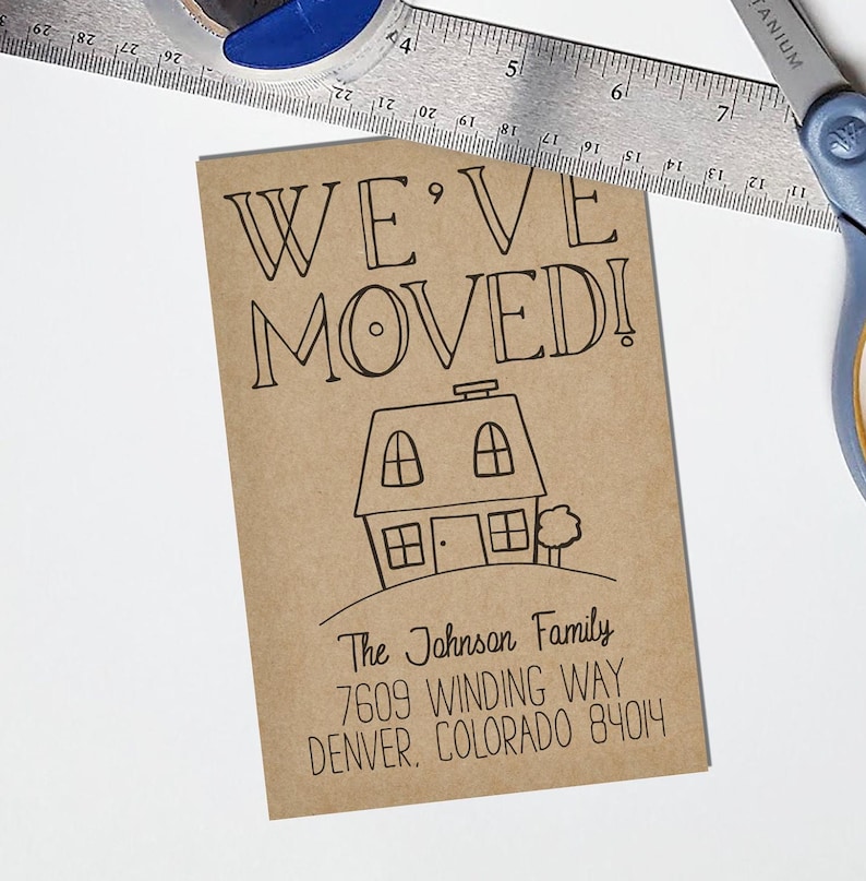 May include: A brown card with the text "WE'VE MOVEDI!" in black lettering. A simple black line drawing of a house with a chimney and a tree is below the text. The text "The Johnson Family" is below the house, followed by the address "7609 WINDING WAY DENVER, COLORADO 84014".
