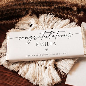 May include: White chocolate bar with a black and white design. The text on the bar reads "congratulations Emilia" with a heart symbol and "North High School | Class of 2023".