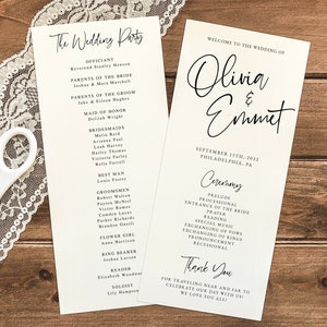 May include: Wedding ceremony program with black calligraphy text on white paper. The program lists the officiant, wedding party, and ceremony details. The program includes the names Olivia and Emmet and the date September 13th, 2022.