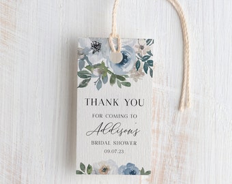 Può includere: Un'etichetta di ringraziamento bianca con fiori ad acquerello blu e bianchi. Il testo recita "Grazie per essere venuto al Bridal Shower di Addison 09.07.23".